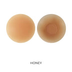 Two beige-colored nipple covers labeled 'Honey' on a white background