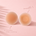 Reusable silicone nipple covers invisible under clothing on a pink background
